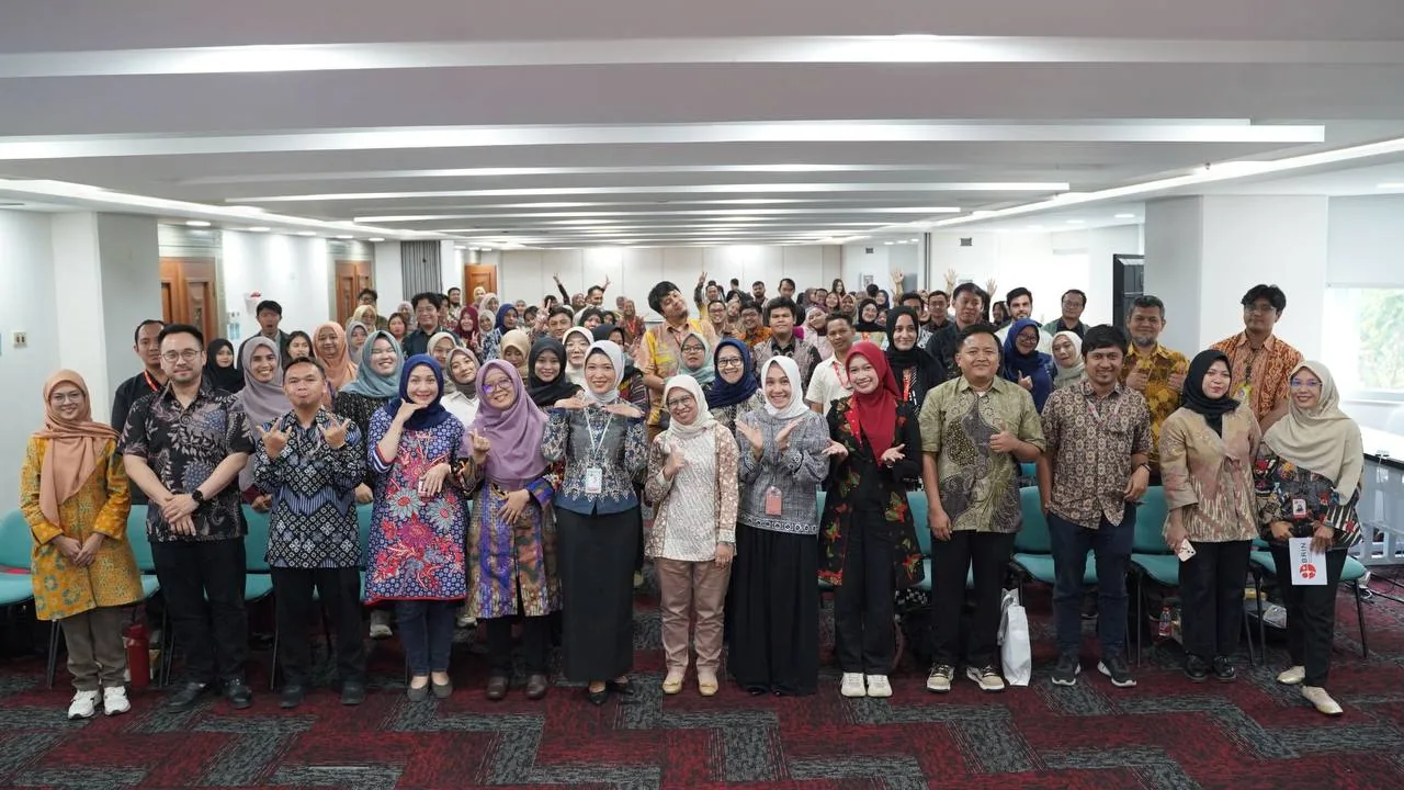 Kelompok besar peserta berfoto bersama di dalam aula