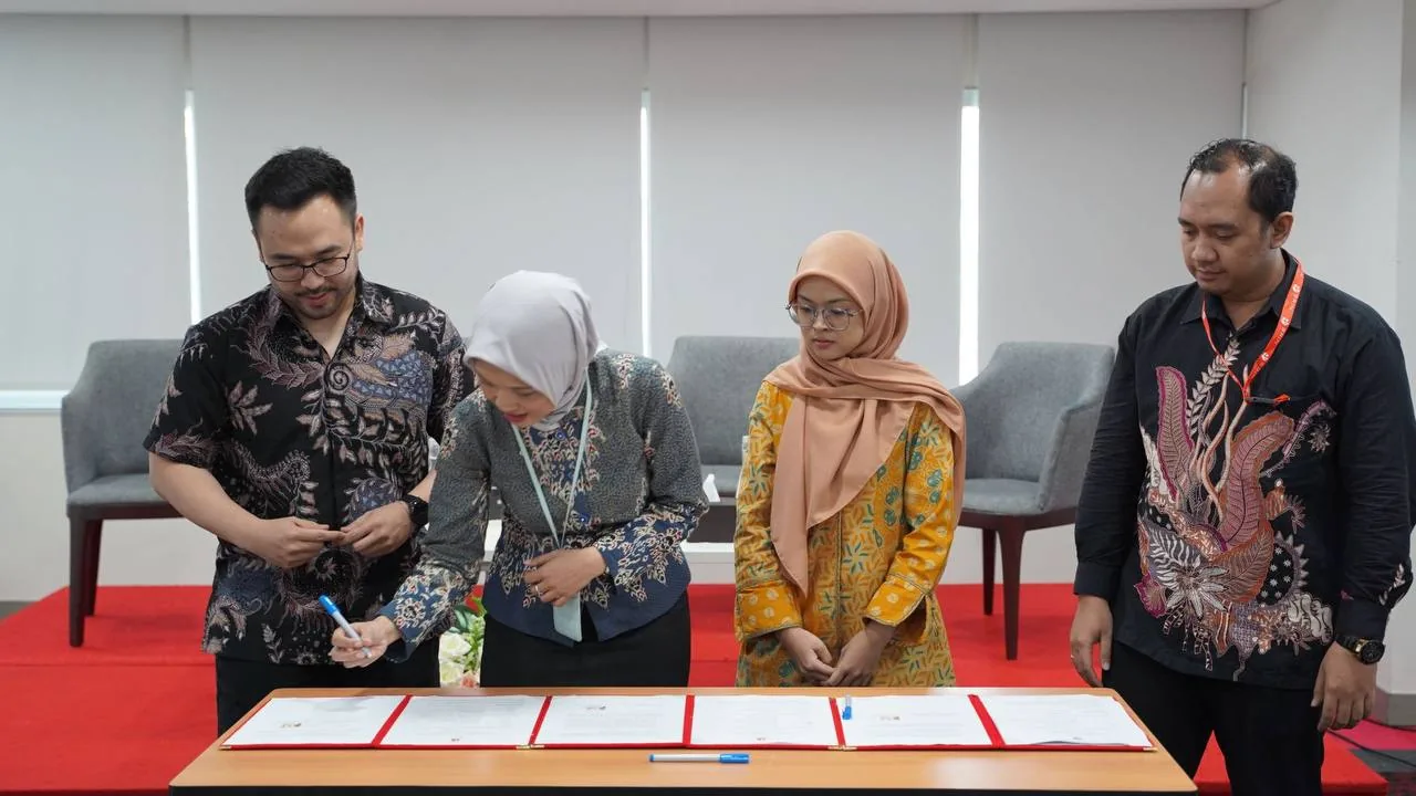 Seorang peserta menandatangani dokumen sementara tiga orang mendampingi